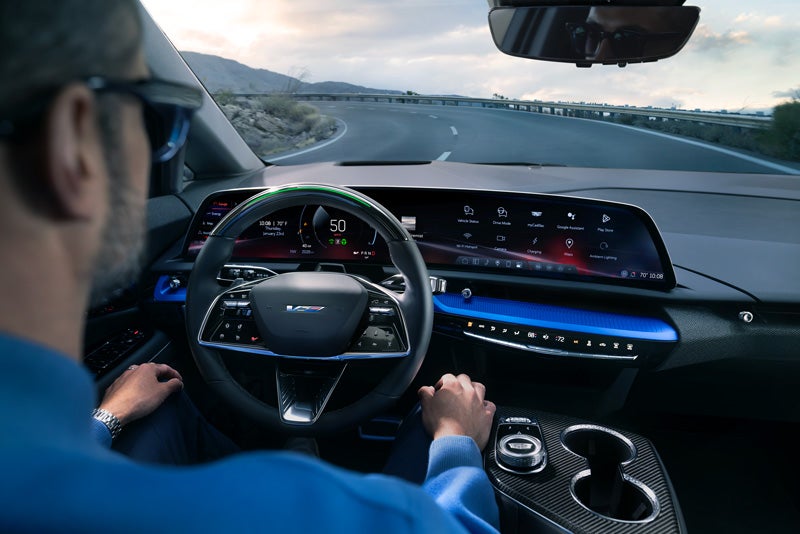 Front View of the 2026 OPTIQ-V Driving Through the Dusk Utilizing its Headlights | Wallace Cadillac, LLC in Stuart FL